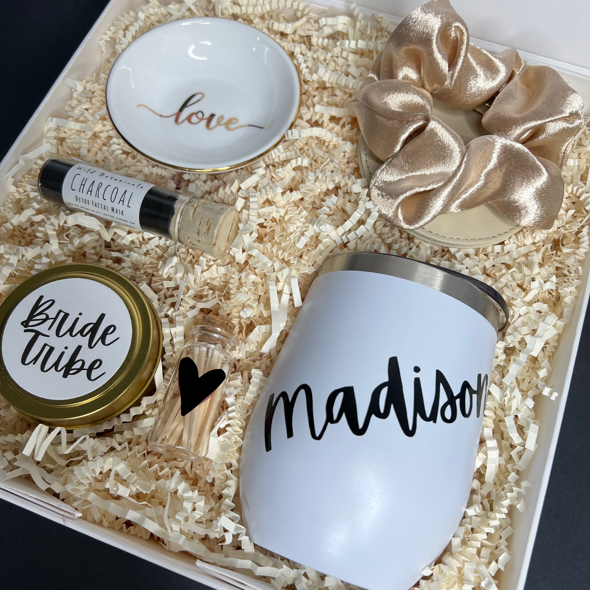 Personalized Bridesmaid Proposal box filled with black, gold and white products. Contains travel size candle with custom sticker, satin scrunchie, charcoal clay face mask, compact mirror, ring dish, personalized 12oz tumbler, match jar with striker.